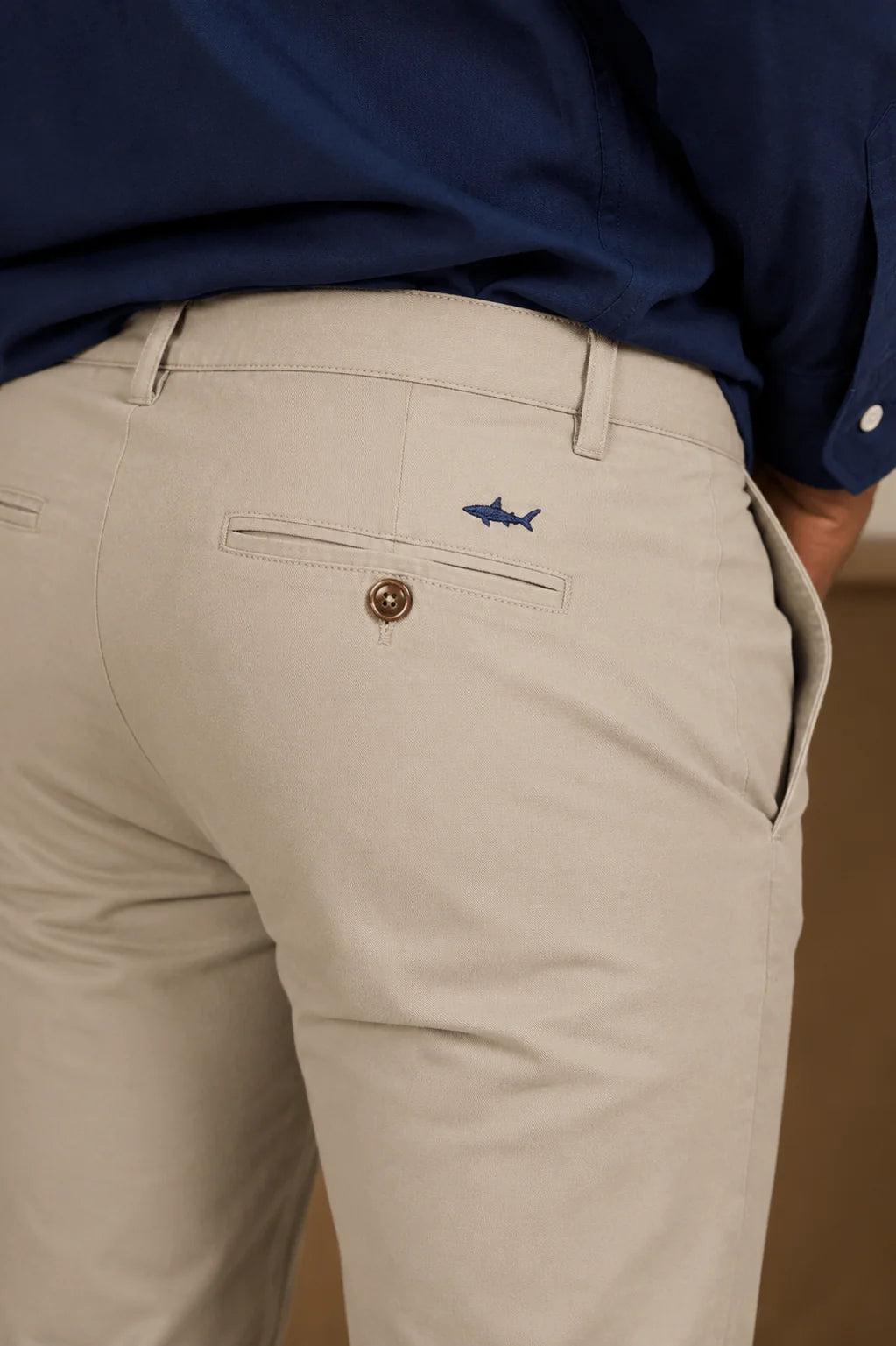 Hombre con pantalón beige y camisa azul oscura tipo lino, mostrando el caído y el ajuste de la prenda