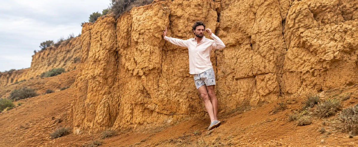 Hombre con camisa palo rosa tipo lino y pantaloneta en un paisaje seco de tierra caliente colombiana